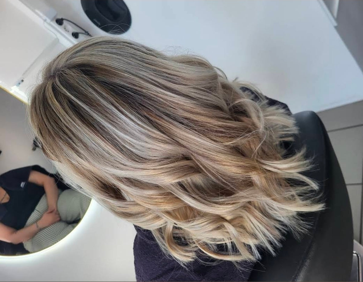 Balayage blond aux boucles lumineuses réalisé à Seraing